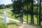 skaczący rowerzysta na tle drzew i flag z logotypem Małopolska